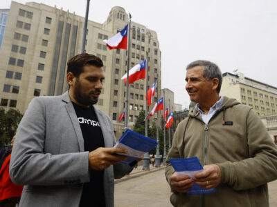 Voluntario entrega folleto informativo sobre proceso de participación.